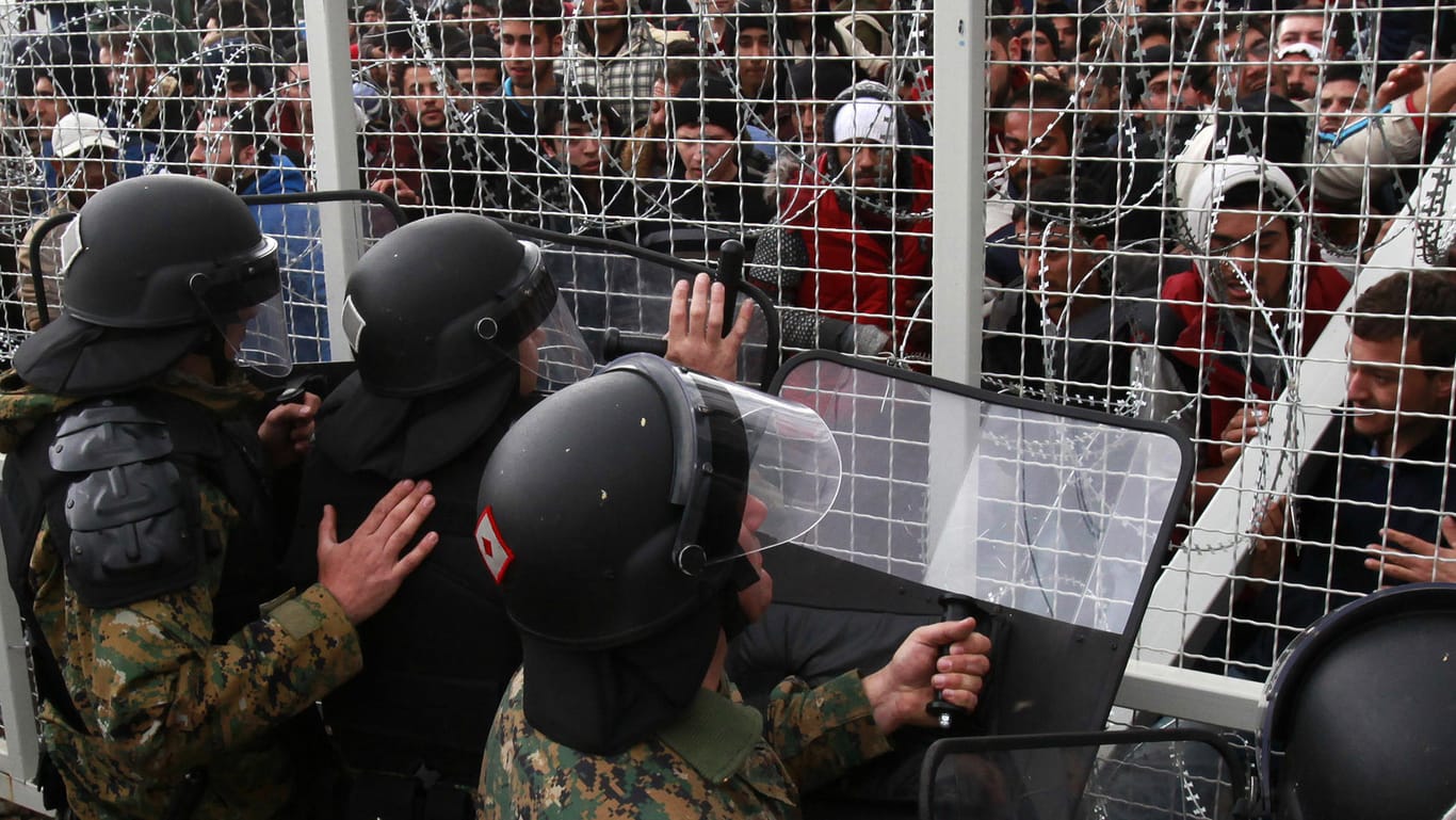 Mazedonische Polizisten in Gevgelija versuchen Flüchtlinge daran zu hindern, einen Grenzzaun zu durchbrechen.