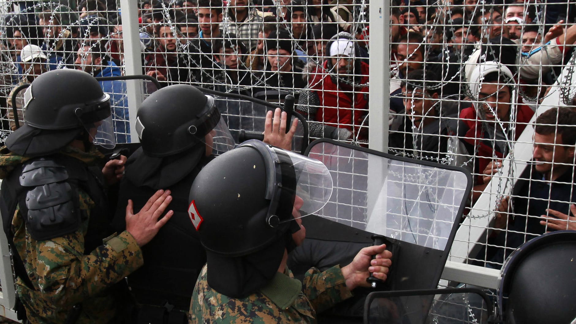Mazedonische Polizisten in Gevgelija versuchen Flüchtlinge daran zu hindern, einen Grenzzaun zu durchbrechen. Mazedonische Polizisten in Gevgelija versuchen Flüchtlinge daran zu hindern, einen Grenzzaun zu durchbrechen.