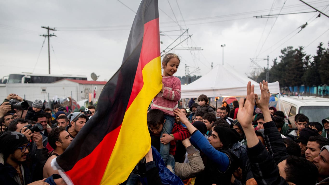 Wunschziel Deutschland: Flüchtlinge im griechischen Idomeni schwenken eine Deutschlandfahne.
