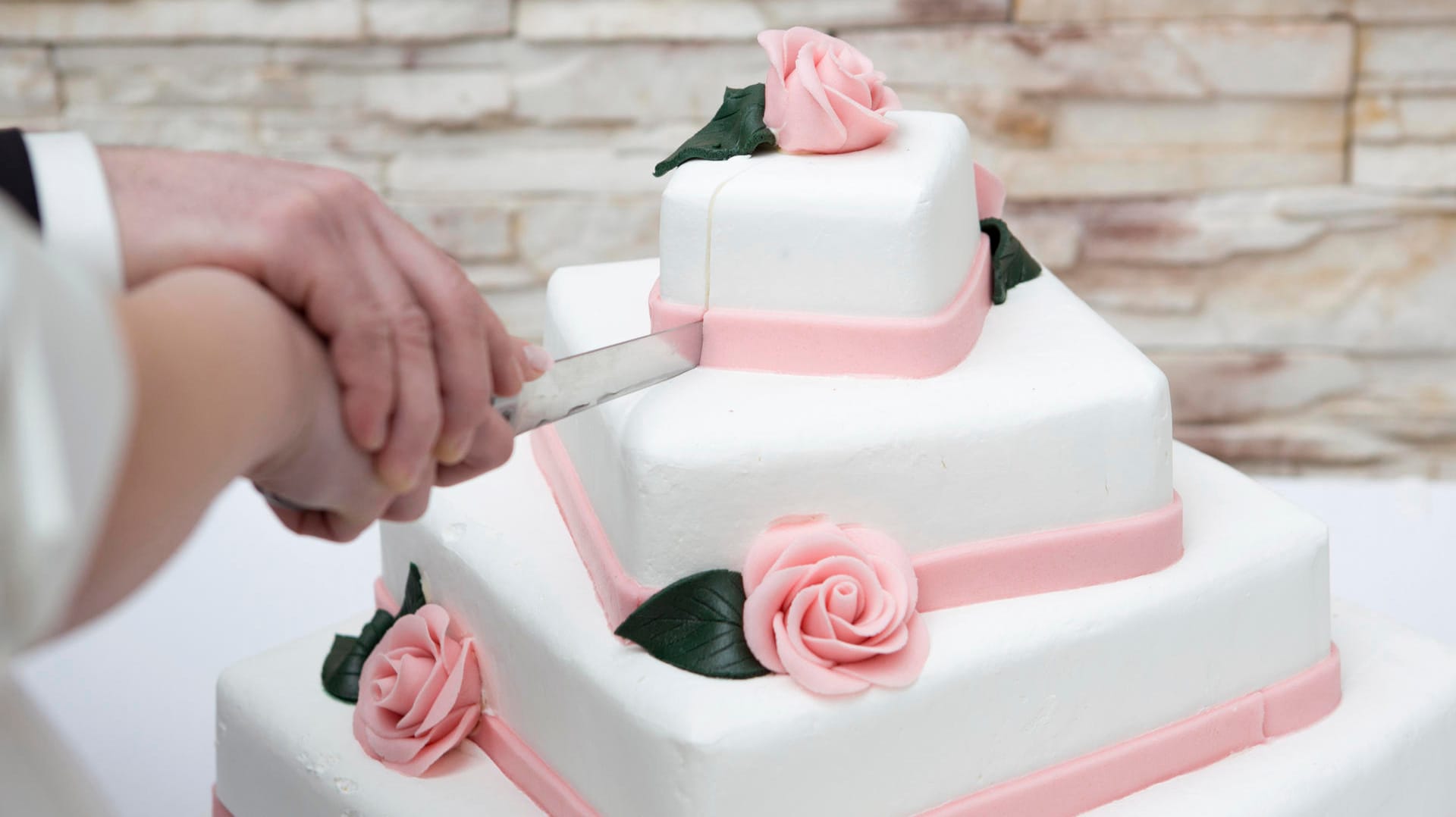 Mit weißem Fondant und Rosen aus Marzipan wirkt die Torte romantisch und festlich.