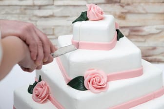 Mit weißem Fondant und Rosen aus Marzipan wirkt die Torte romantisch und festlich.