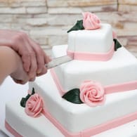 Mit weißem Fondant und Rosen aus Marzipan wirkt die Torte romantisch und festlich.