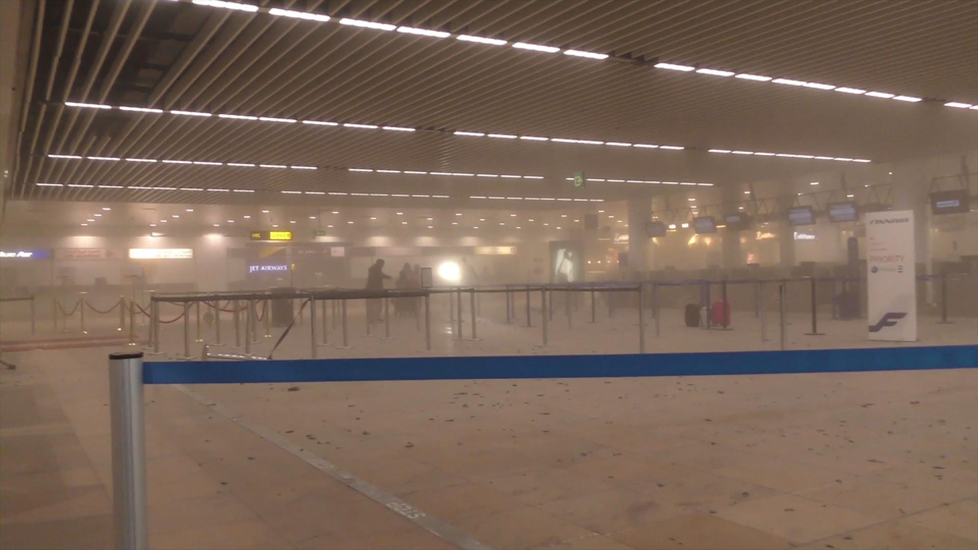 Dieses Bild zeigt Reisende im rauchgefüllten Terminal des Brüsseler Flughafens.
