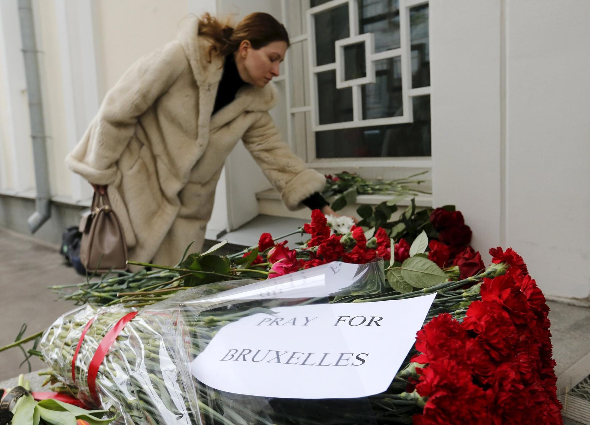 In Moskau legt eine Frau Blumen für die Opfer der Brüsseler Anschläge vor der belgischen Botschaft nieder.