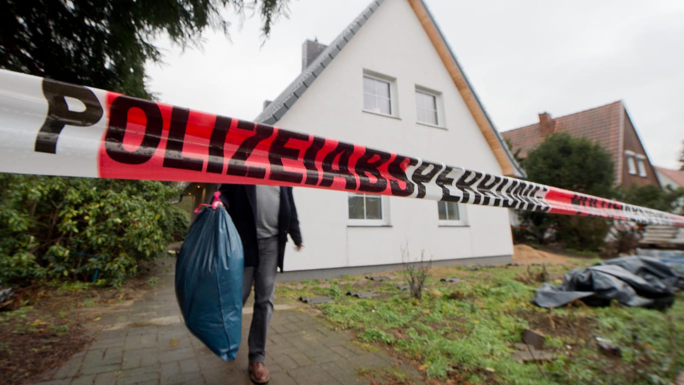Ein Ermittler der Polizei trägt am 10.02.2016 Beweismittel aus dem Haus des Opfers in Celle.