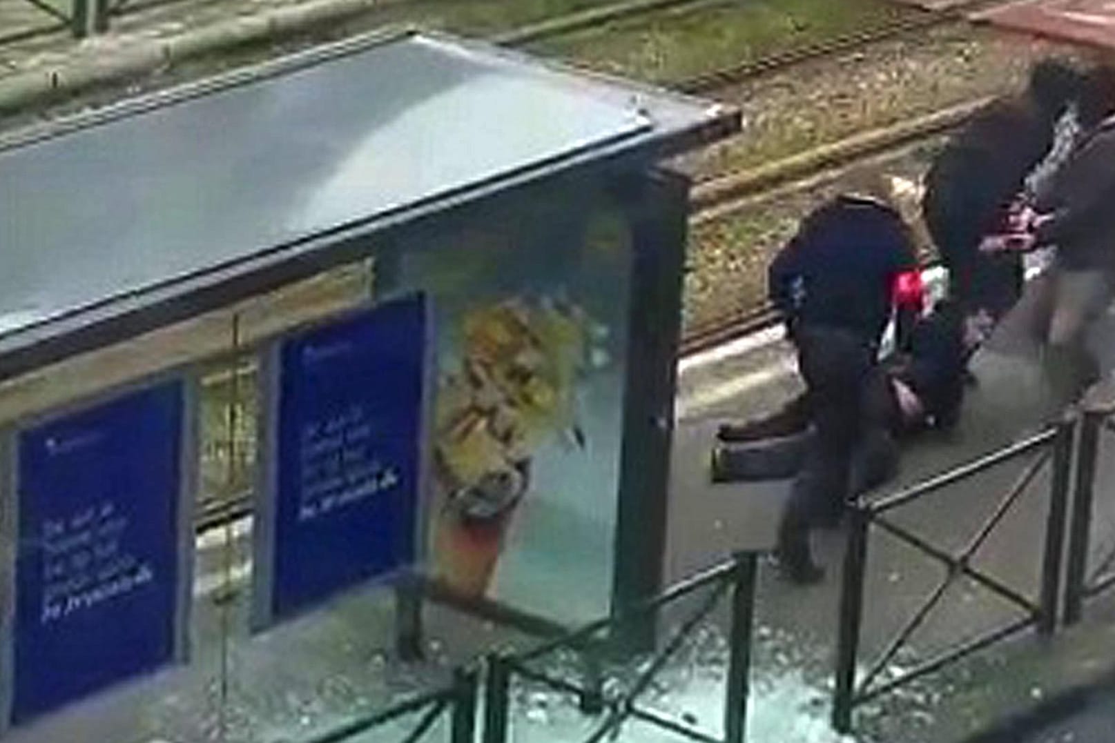 Belgische Polizisten bringen einen Verdächtigen an einer Straßenbahnhaltestelle zu Boden.