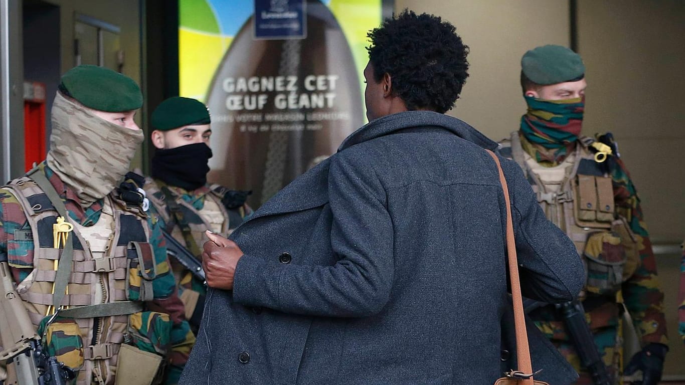 Soldaten durchsuchen in Brüssel einen Mann.