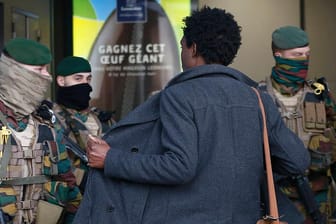 Soldaten durchsuchen in Brüssel einen Mann.