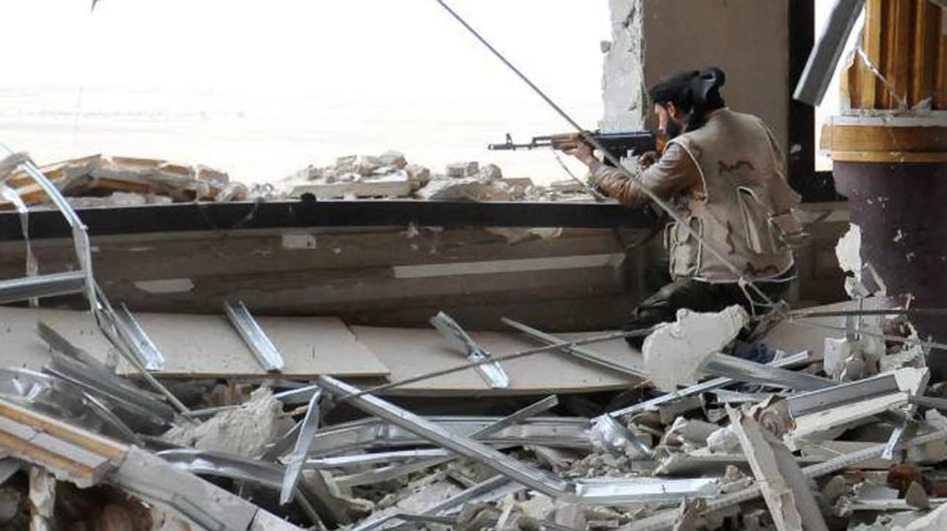 Kampf gegen den IS in Palmyra: Ein syrischer Soldat belauert von einem zerschossenen Gebäude aus die Frontlinie.