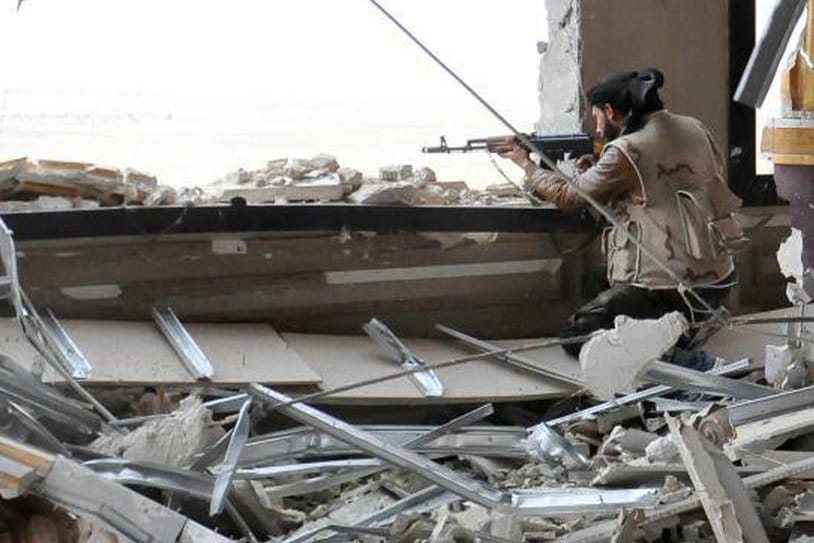 Kampf gegen den IS in Palmyra: Ein syrischer Soldat belauert von einem zerschossenen Gebäude aus die Frontlinie.