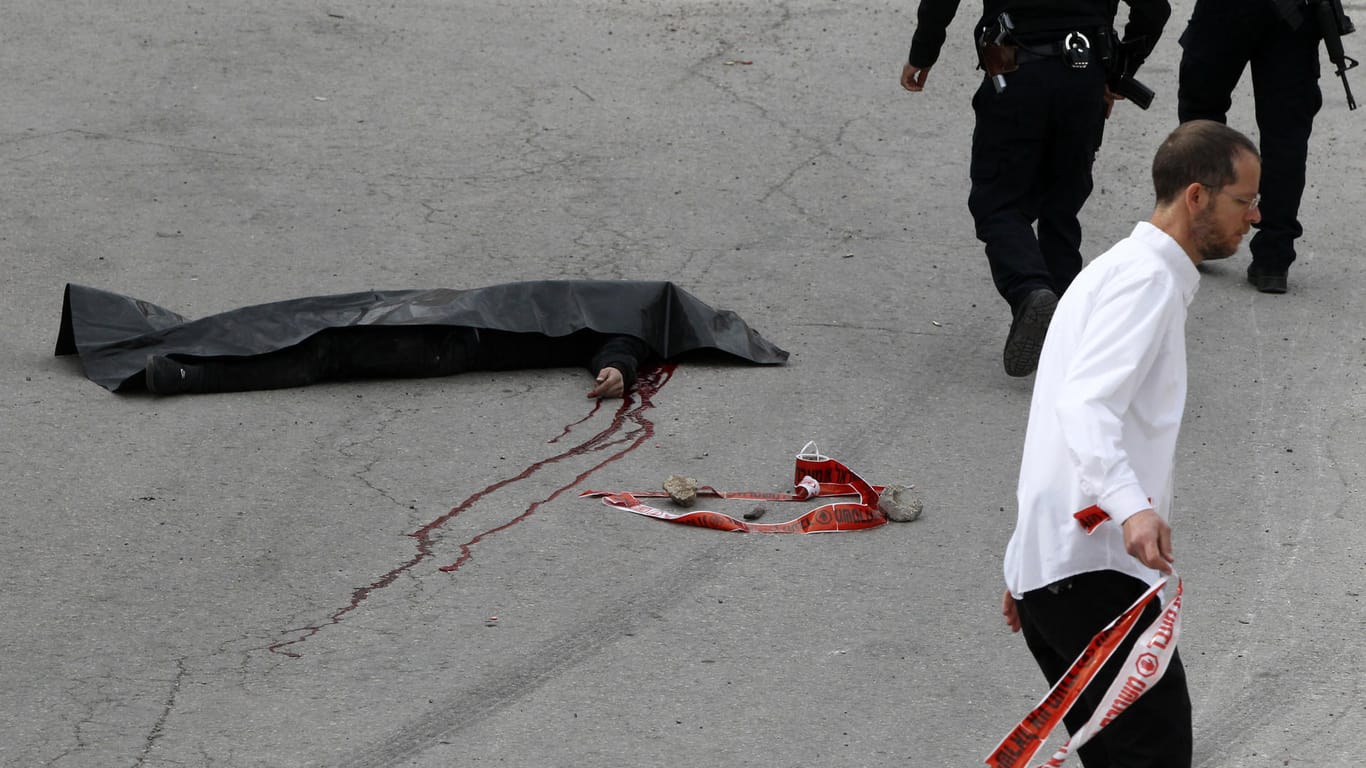 Eine schwarze Folie bedeckt die Leiche des erschossenen Palästinensers.