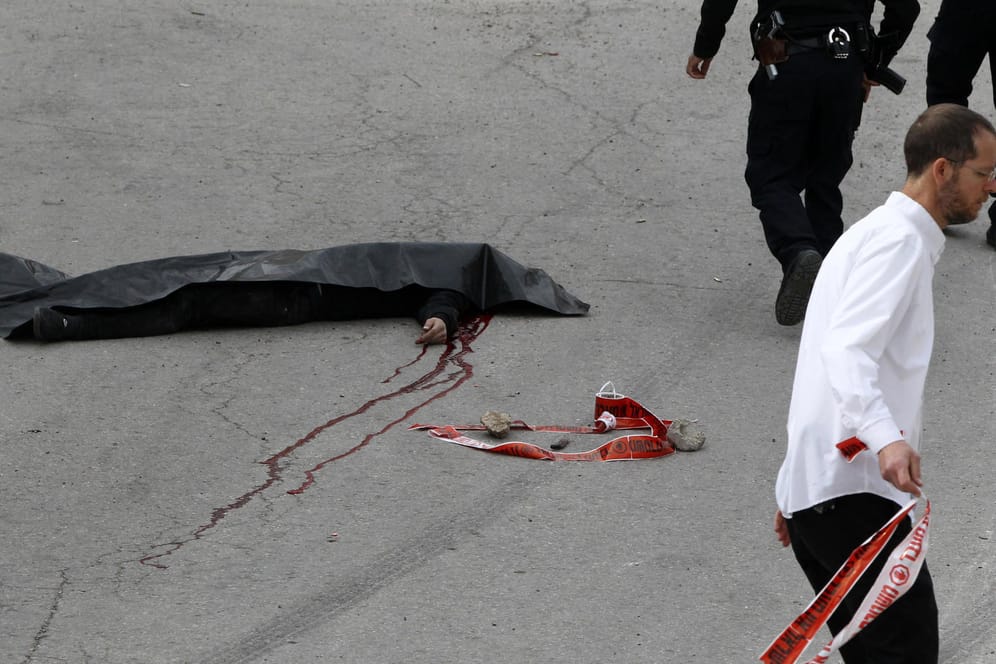Eine schwarze Folie bedeckt die Leiche des erschossenen Palästinensers.
