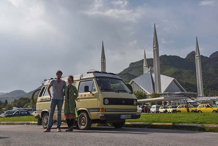 Christian Nieth und Elisabeth Hartmann stehen neben ihrem Bus vor der Faisal-Moschee in Islamabad, Pakistan.