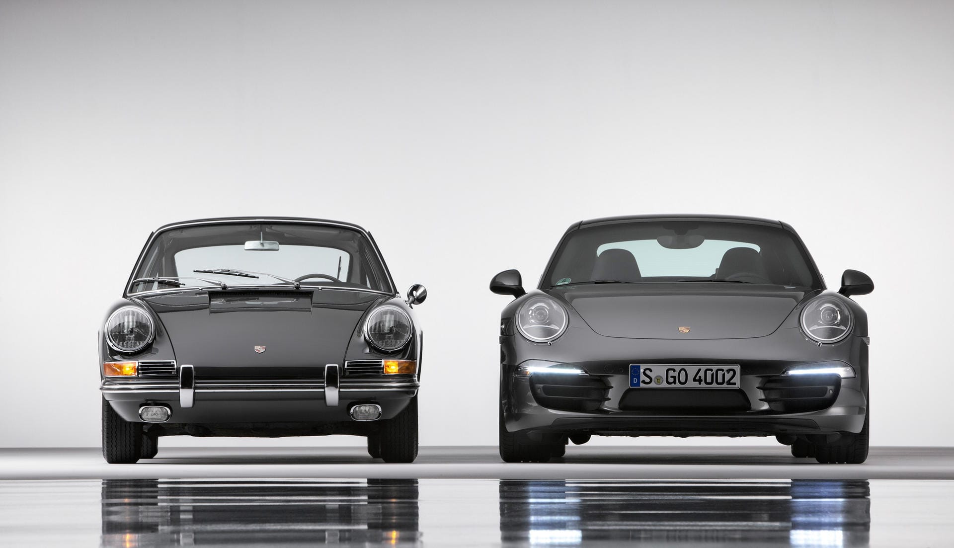 Mythos Porsche 911: Seit seiner Präsentation 1963 entwickelt der Sportwagenbauer den Elfer bis heute stetig weiter. Im Bild links ein 2.0 Coupé von 1964 und rechts ein Carrera 4S Coupé der aktuellen Baureihe 991.
