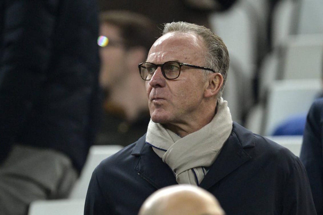 Karl-Heinz Rummenigge blickt in die Bayern-Kurve - und sieht Protest-Banner.