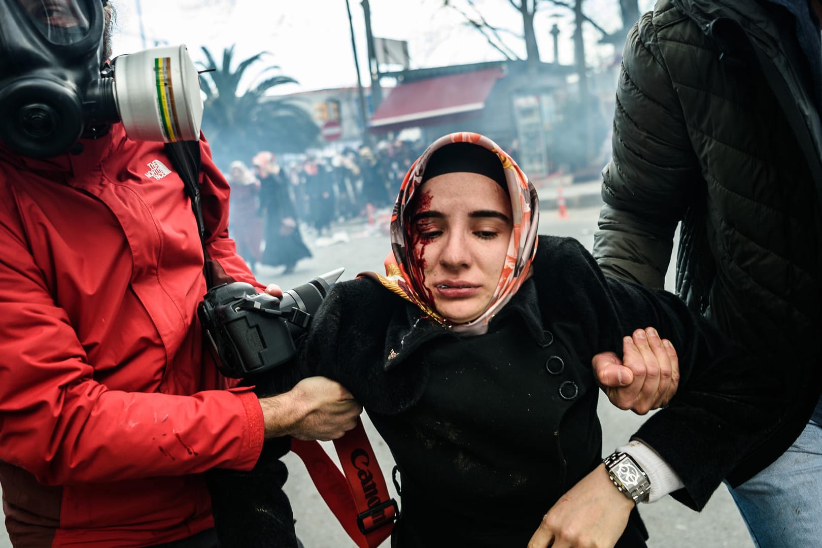 Journalisten bringen eine verletzte Frau vor dem Tränengas der Polizei bei Ausschreitungen vor der Redaktion der Zeitung Zaman in Sicherheit. Die Redaktion wurde zuvor von Sicherheitskräften gestürmt.
