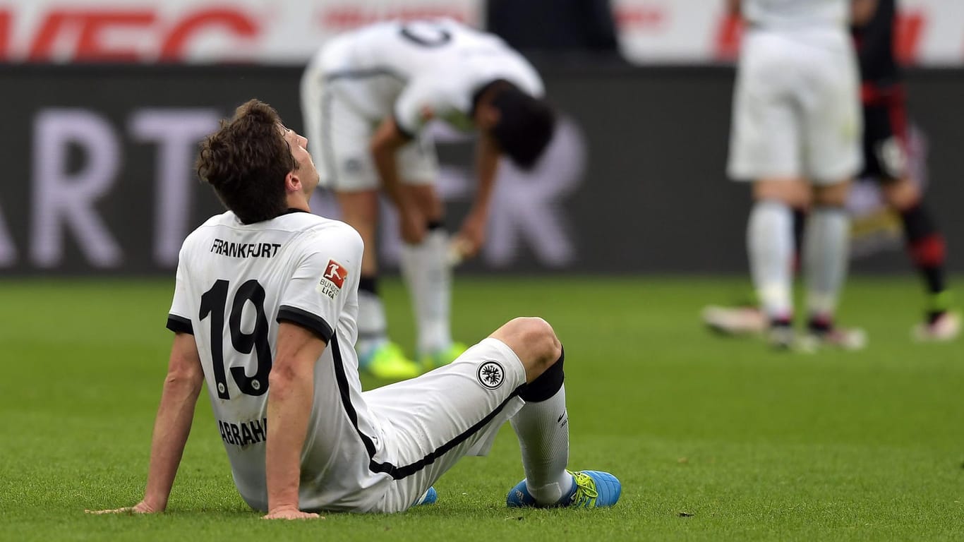 Frankfurts Innenverteidiger David Abraham sitzt nach dem 0:3 bei Bayer Leverkusen am Boden.