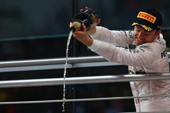 Nico Rosberg feiert seinen Sieg in Shanghai mit Champagner auf dem Podium.