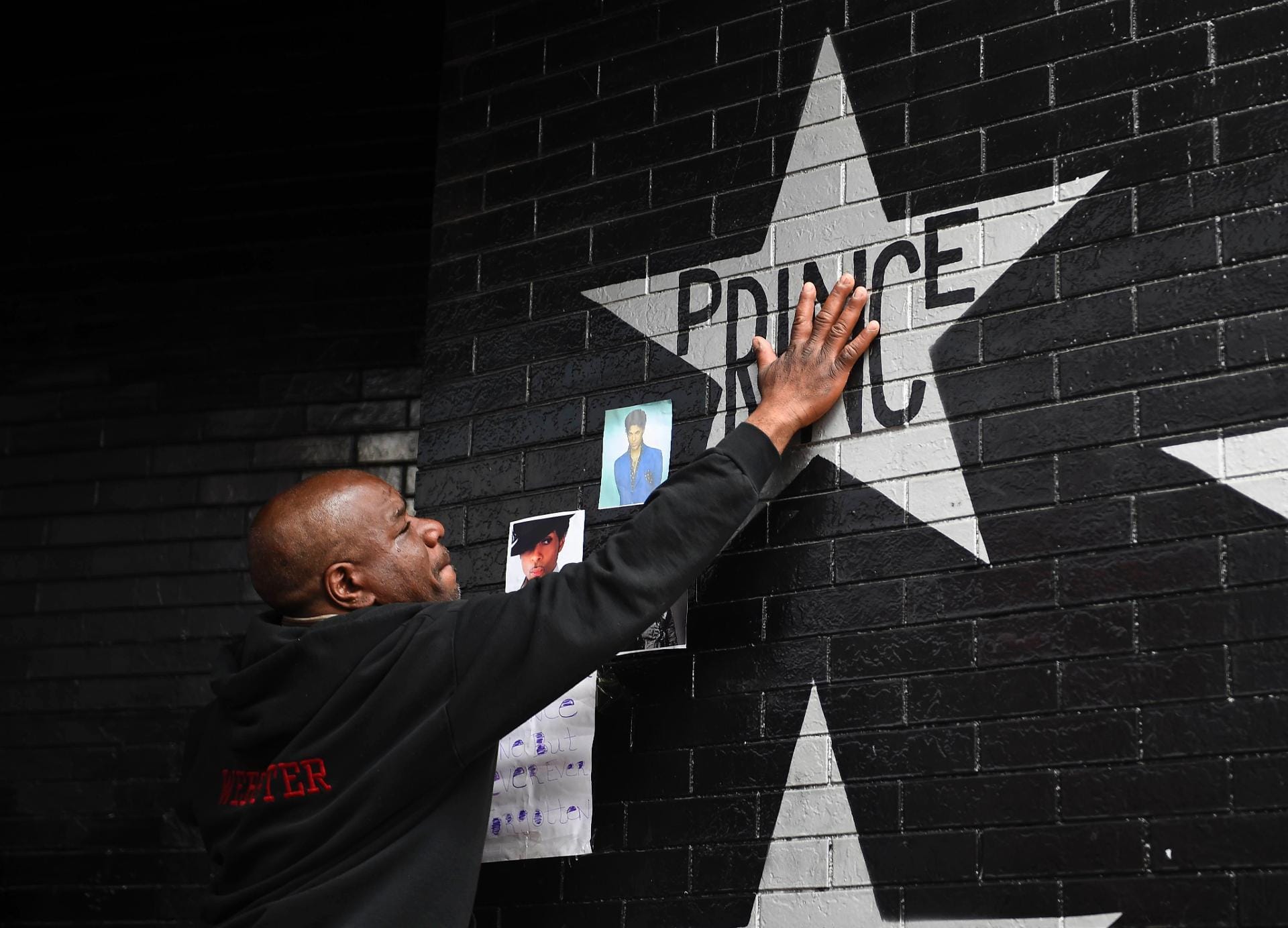 Ein Fan berührt die Wand des Nachtclubs "First Avenue", in dem Prince regelmäßig auftrat. Ein Fan berührt die Wand des Nachtclubs "First Avenue", in dem Prince regelmäßig auftrat.