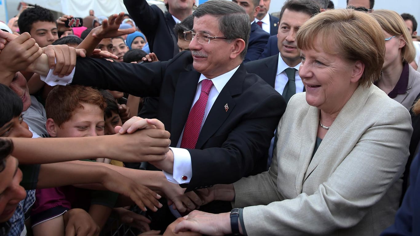 Angela Merkel bei ihrem Türkei-Besuch: Gemeinsam mit dem türkischen Regierungschef Ahmet Davutoglu begrüßt sie syrische Flüchtlinge Gaziantep.