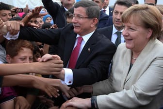 Angela Merkel bei ihrem Türkei-Besuch: Gemeinsam mit dem türkischen Regierungschef Ahmet Davutoglu begrüßt sie syrische Flüchtlinge Gaziantep.
