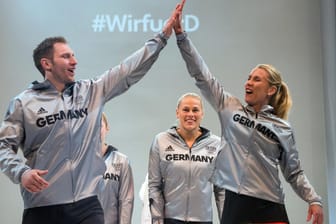 Hockeyspieler Moritz Fürste (li.), die paraolympische Kanutin Edina Müller und Beachvolleyballerin Karla Borger (re.) präsentieren das Outfit für Rio 2016.