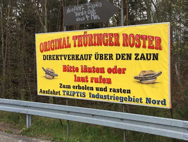 Ein Hinweisschild am Parkplatz weist Bratwurst-Hungrige darauf hin, "über den Zaun" zu kaufen.