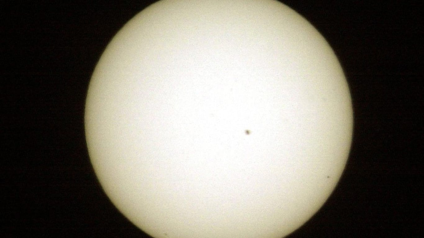 Der schwarze Punkt rechts unten ist Merkur. Dieses Foto wurde 2003 mit einer Brennweite von 1200 mm aufgenommen. Der große Punkt nahe der Mitte ist ein Sonnenfleck.