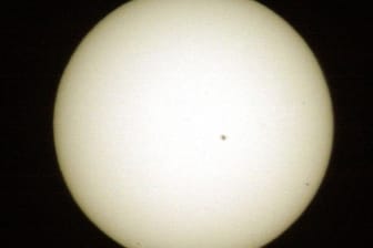 Der schwarze Punkt rechts unten ist Merkur. Dieses Foto wurde 2003 mit einer Brennweite von 1200 mm aufgenommen. Der große Punkt nahe der Mitte ist ein Sonnenfleck.