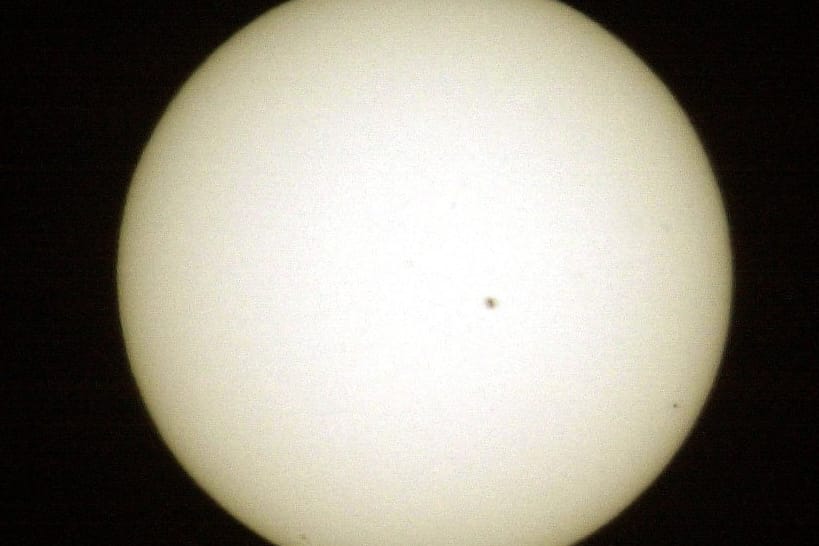 Der schwarze Punkt rechts unten ist Merkur. Dieses Foto wurde 2003 mit einer Brennweite von 1200 mm aufgenommen. Der große Punkt nahe der Mitte ist ein Sonnenfleck.