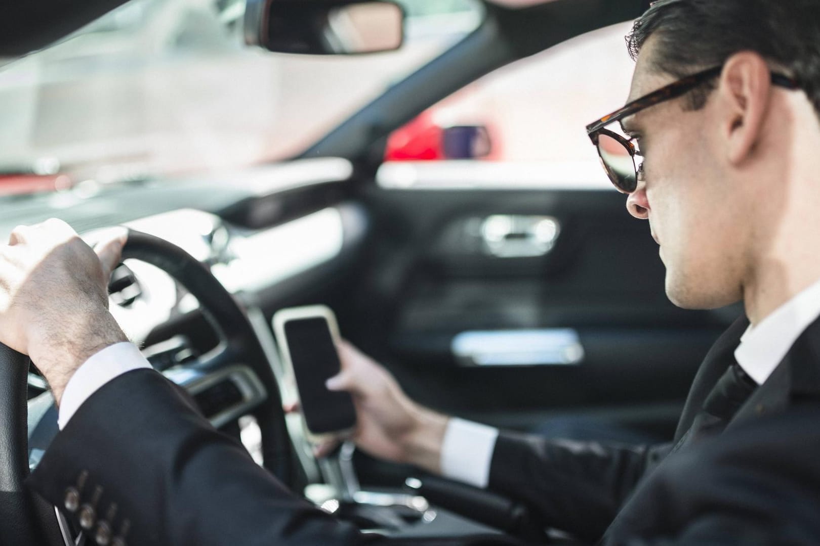 Das Handy während des Fahrens im Auto halten, kann erlaubt sein.