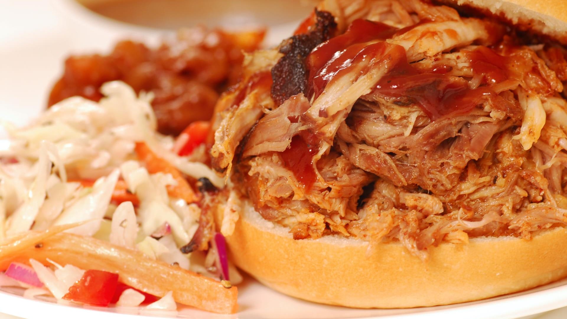 Zu Pulled Pork passen verschiedene Beilagen wie Coleslaw, Baked Beans oder Wedges.