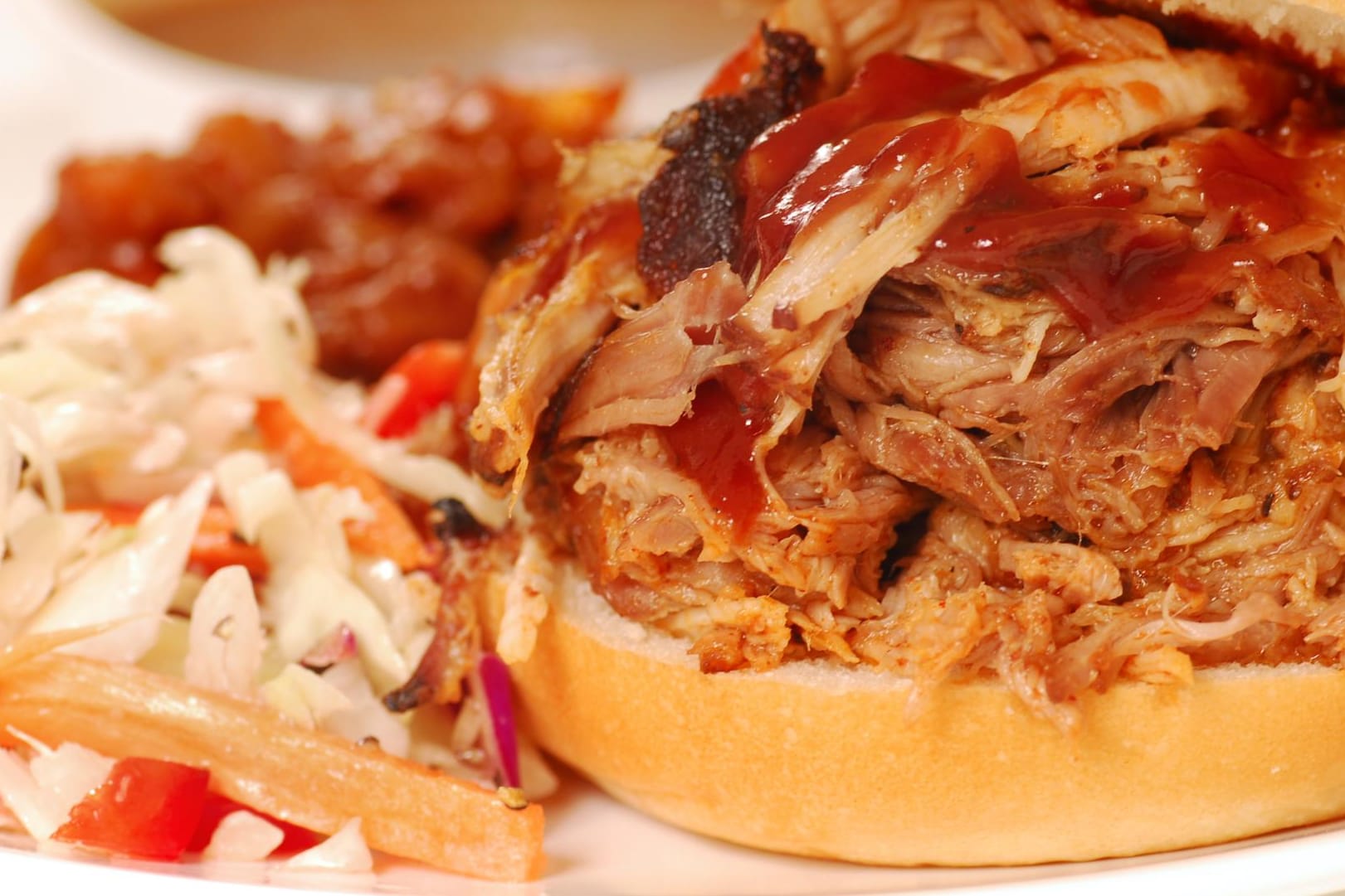 Zu Pulled Pork passen verschiedene Beilagen wie Coleslaw, Baked Beans oder Wedges.