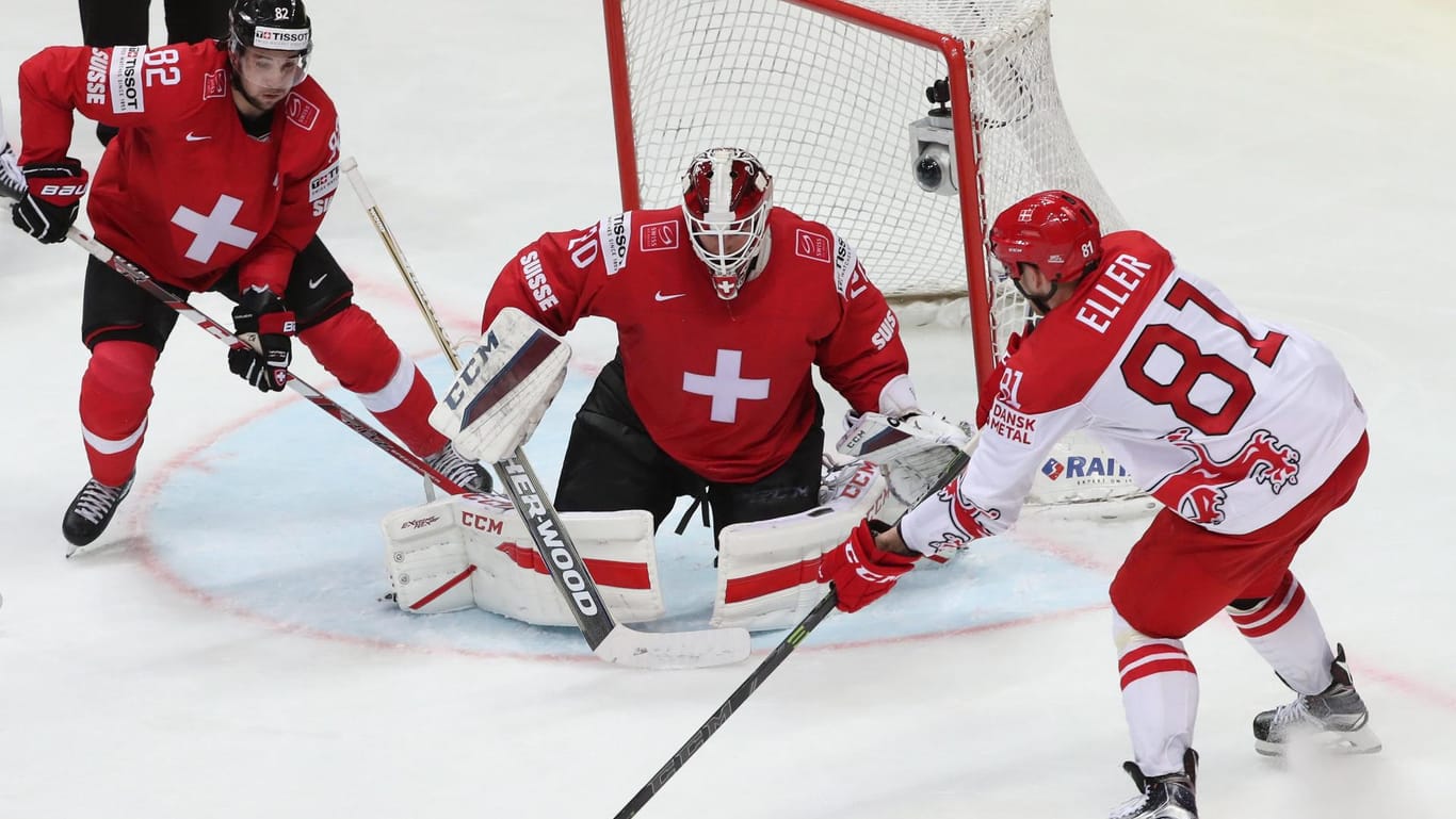 Der Däne Lars Eller (re.) versucht die beiden Schweizer Reto Berra (Mitte) und Simon Moser zu überwinden.