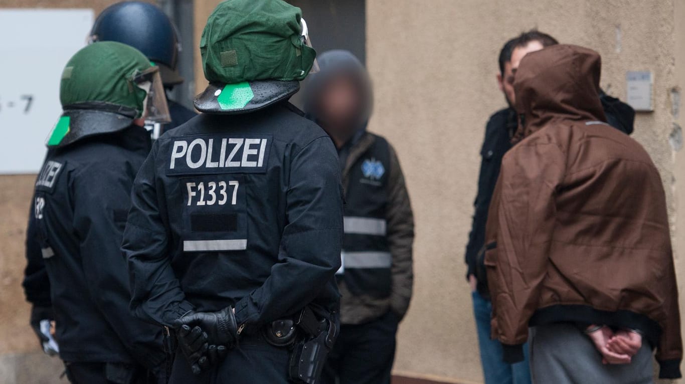 Auseinandersetzungen unter Flüchtlingen in BerlinaPolizisten mit festgenommenen Flüchtlingen. Das BKA ermittelt gegen 40 Personen.