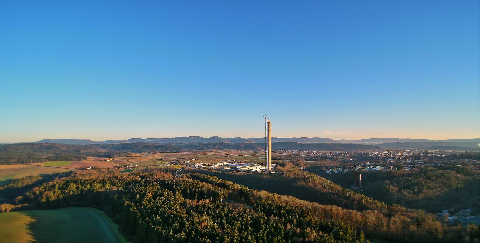 Der Testturm für Aufzüge ragt neben dem Städtchen Rottweil aus der beschaulichen Landschaft.
