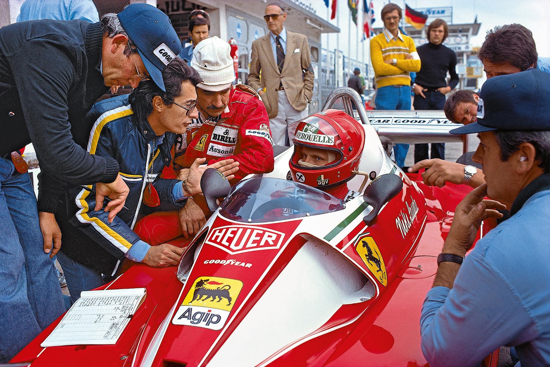 Daniele Audetto (Ferraris Team Manager) und Clay Regazzoni sprechen mit Niki Lauda, der im Cockpit sitzt. Die Aufnahme stammt vom 1. August 1976. An dem Tag verunglückte der Österreicher auf der Strecke, überlebte aber den Unfall. Doch seitdem wurden auf der Nordschleife keine Formel-1-Rennen mehr bestritten.