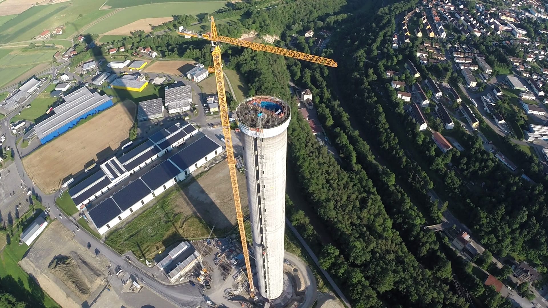 Der Testturm für Aufzüge ragt neben dem Städtchen Rottweil aus der beschaulichen Landschaft. Auf dem Bild sieht man noch den Hochhauskran, der schwere Teile auf den Turm hievt.