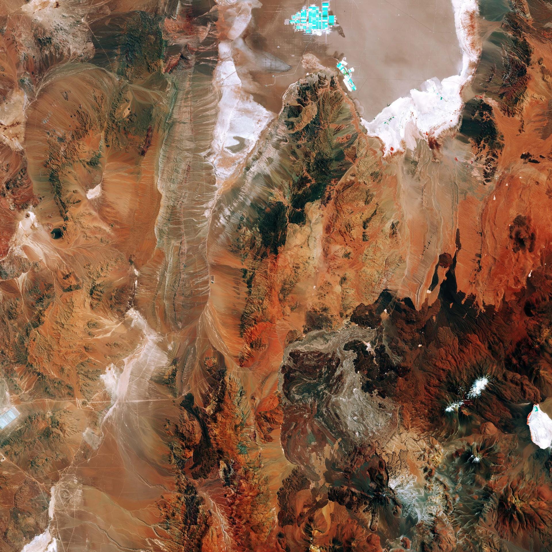 Das Satellitenbild zeigt die östliche Atacama-Wüste in Chile. In dem Gebiet 200 km östlich der Stadt Antofagasta gibt es kaum Vegetation. Es ist eine der trockensten und einsamsten Landschaften der Erde. Oben im Bild ist der Salar de Atacama, ein Salzwassersee, der als Binnengewässer keinen Abfluss zum Ozean hat, zu sehen. Der See ist die weltgrößte und reinste aktive Quelle von Lithium.