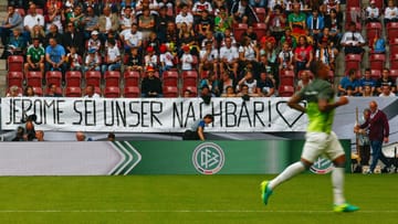EM-Vorfreude in Augsburg: Gut gelaunte Fans empfangen die deutsche Nationalmannschaft - und haben zahlreiche herzliche Banner für den von Alexander Gauland wüst beschimpften Jerome Boateng parat.