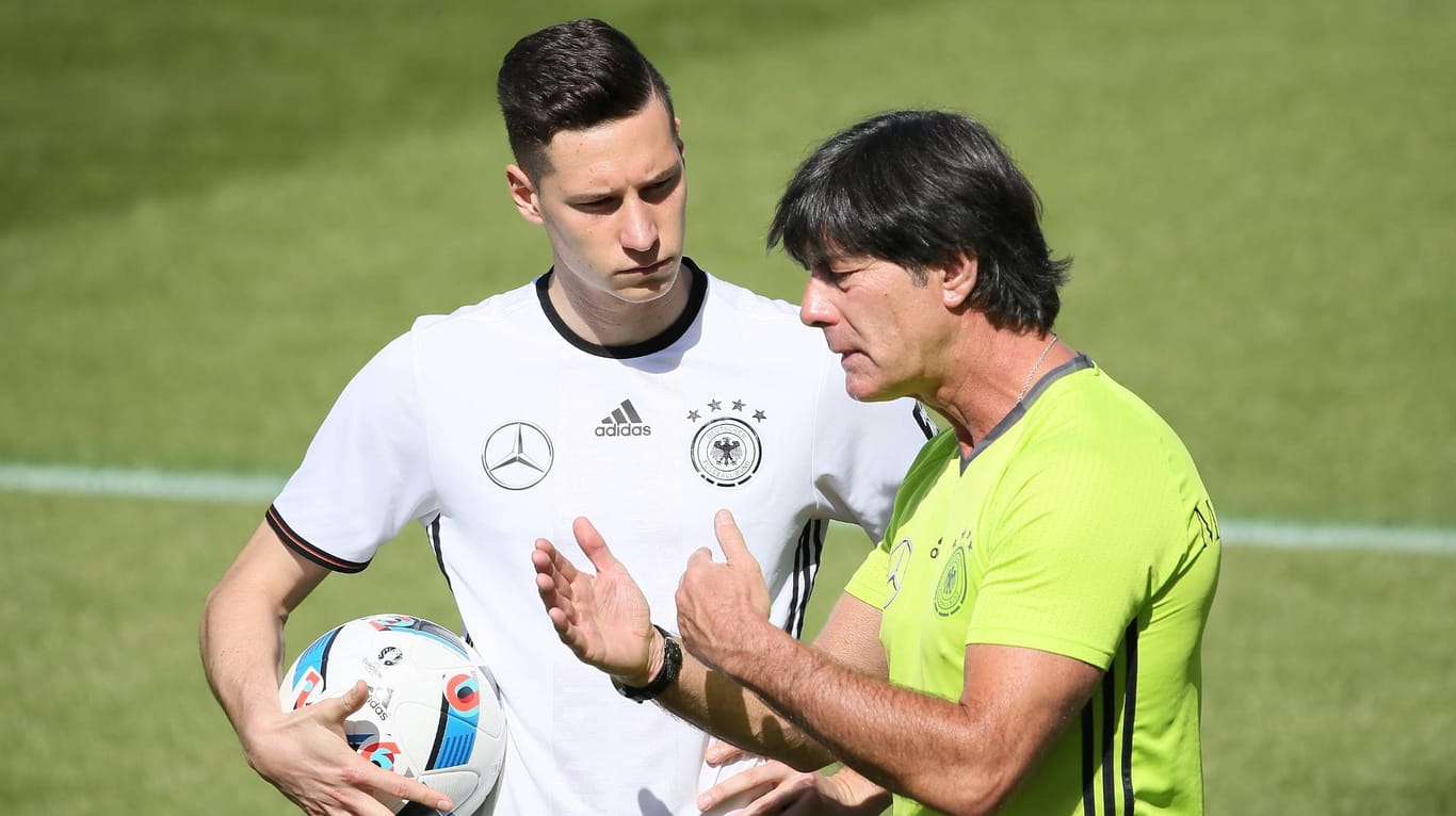 Bundestrainer Jogi Löw (re.) erklärt Julian Draxler seine taktische Vorstellung.