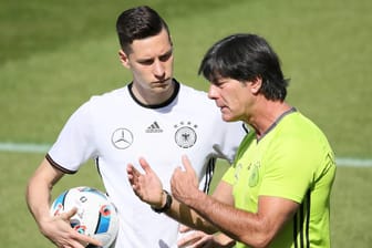 Bundestrainer Jogi Löw (re.) erklärt Julian Draxler seine taktische Vorstellung.