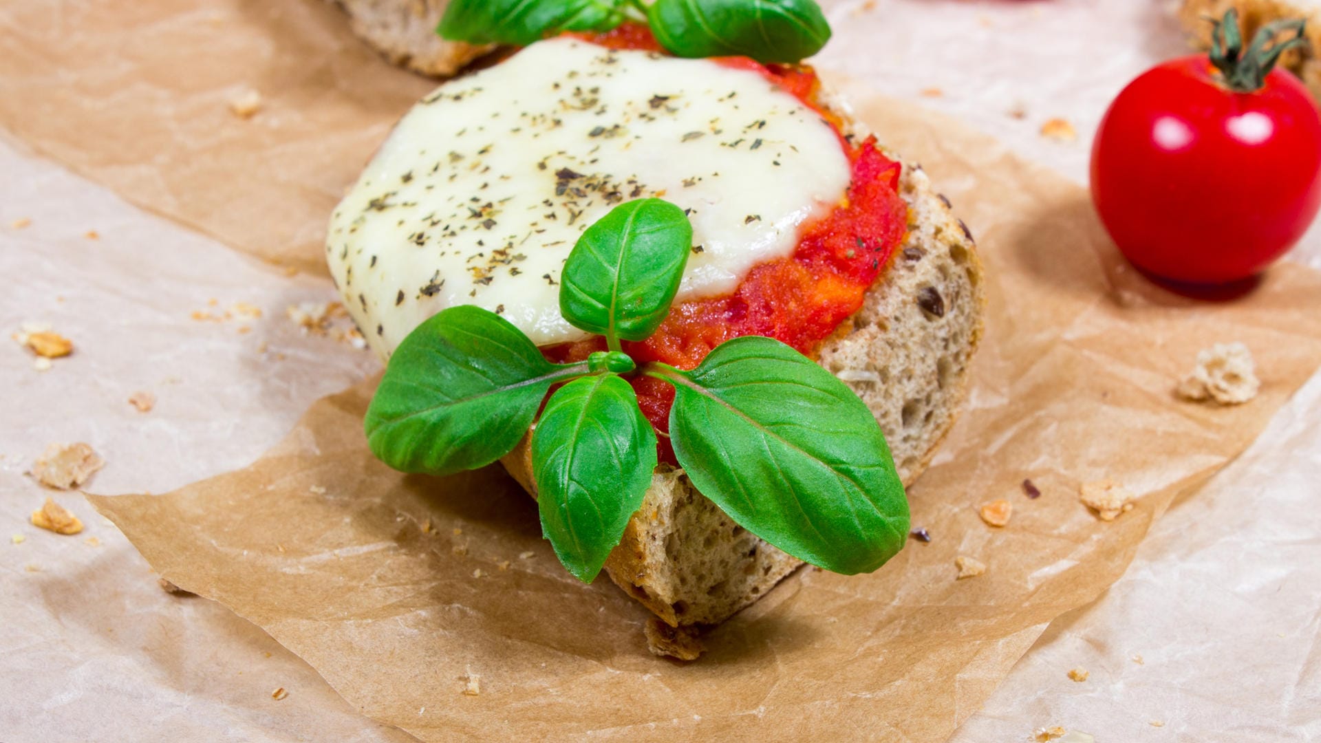 Bruschetta kommt klassisch ohne Käse aus - diese Variante mit Mozzarella wird Sie deshalb umso mehr begeistern.