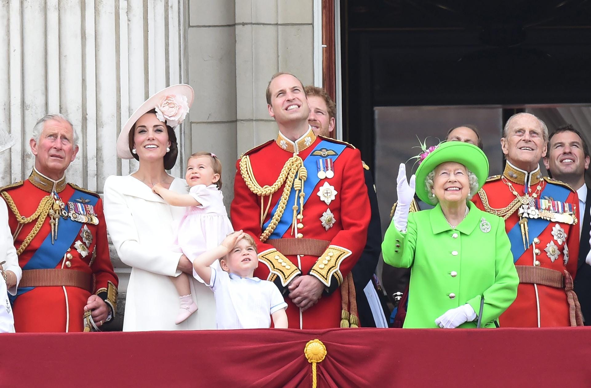 Prinz Charles, Herzogin Kate und Prinz William mit ihren Kindern Charlotte und George, Queen Elizabeth II. und Prinz Philip sowie im Hintergrund Prinz Harry beobachten die Militärjets der Royal Air Force, die über London hinweg donnerten und die Landesfarben blau-weiß-rot in den Himmel malten.