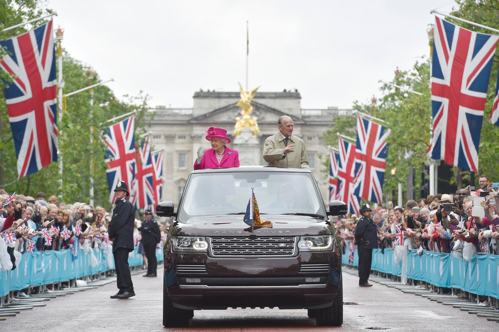 Im pinken Mantel und passenden Hut fuhr Queen Elizabeth II. gemeinsam mit ihrem Gatten Prinz Philip im offenen Wagen vor.