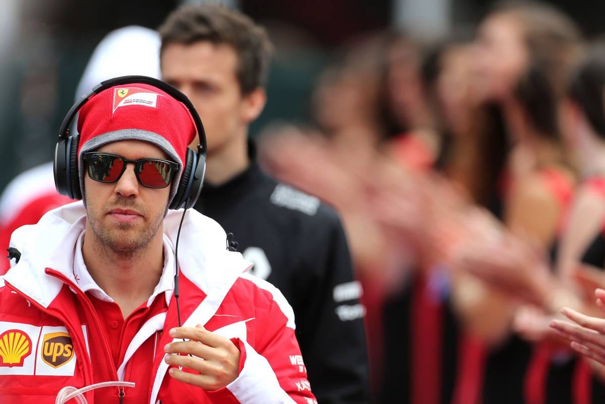 Fokussiert: Ferrari-Pilot Sebastian Vettel erscheint mit Sonnenbrille und Mega-Kopfhörer zur Fahrerparade.