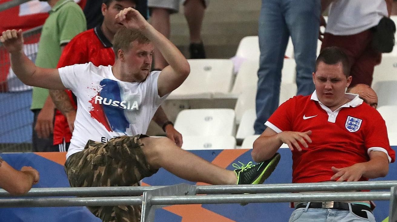 Russische Anhänger greifen einen englischen Fan im Stadion an.