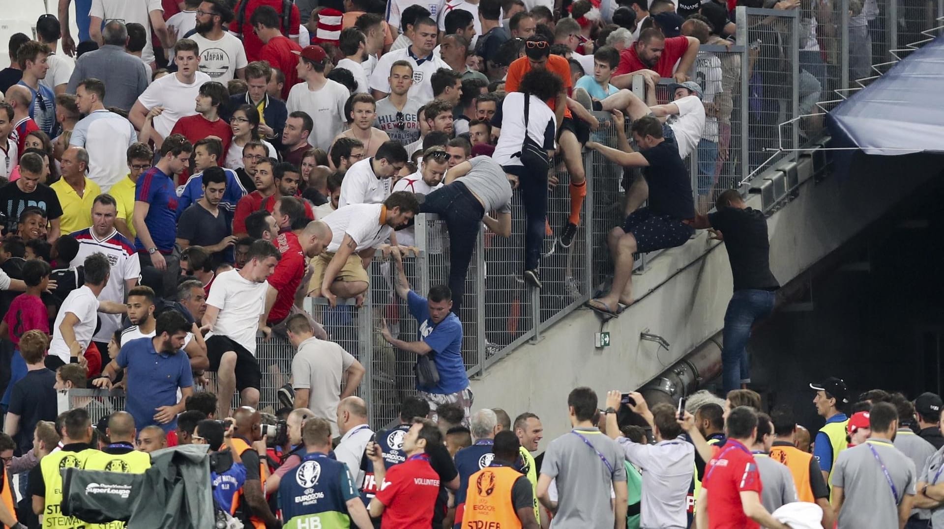 Fans auf der Tribüne flüchten vor prügelnden Hooligans.