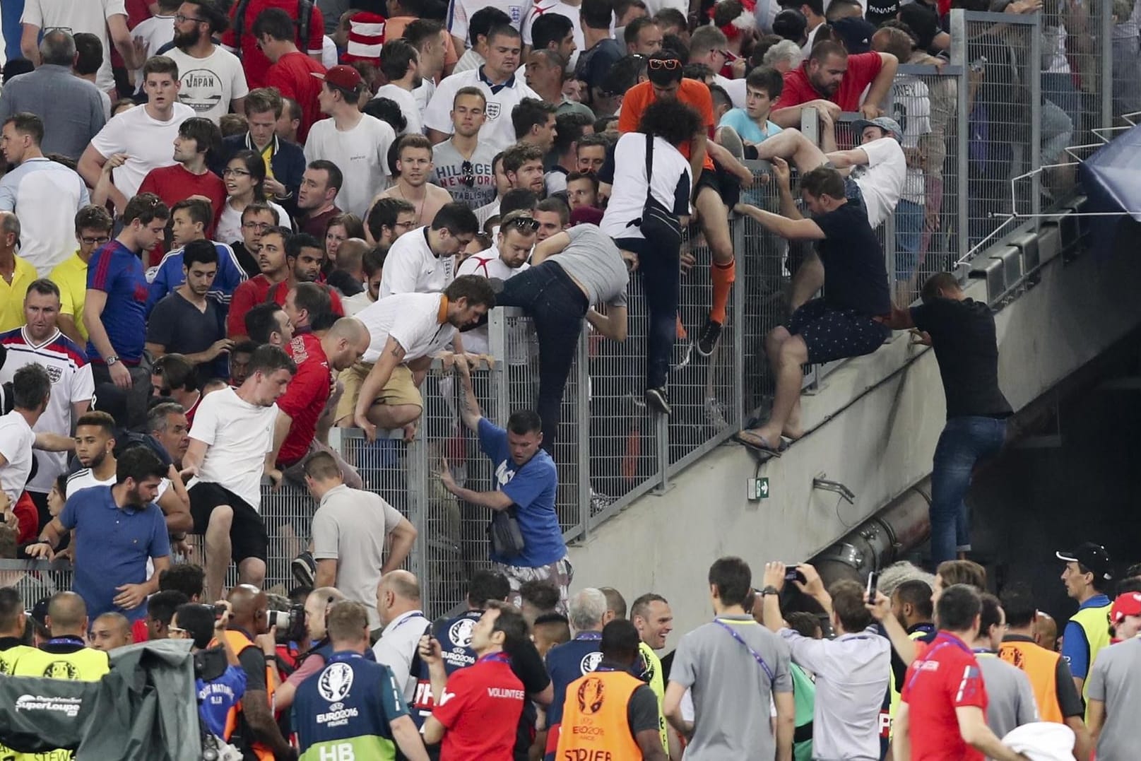 Fans auf der Tribüne flüchten vor prügelnden Hooligans.