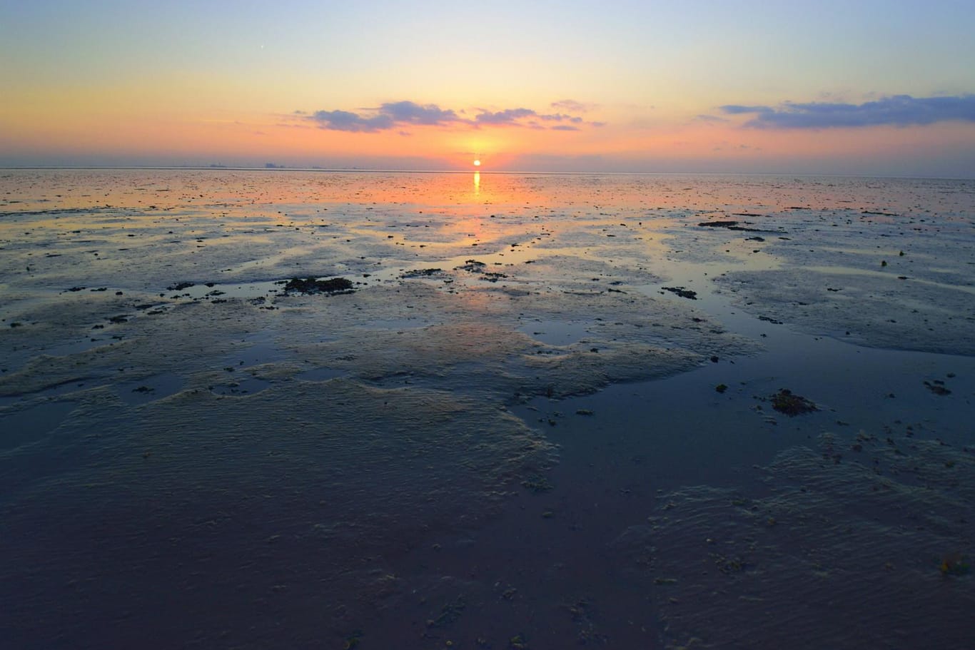 Sonnenuntergang über dem Wattenmeer bei Ebbe (Symbolbild): Die nahende Flut kann schnell gefährlich werden.